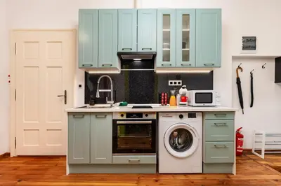 a kitchen with blue cabinets and a washing machine at Apt Kosmos in the best Central Area in Plovdiv in Plovdiv