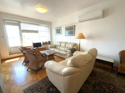a living room with a couch and a table at Zaimov Penthouse with great view in Sofia