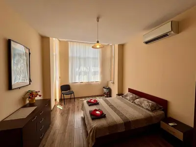 a bedroom with a bed and a desk and a window at Comfy Apt next to Palace of Justice in Sofia