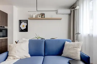 a blue couch in a living room with a window at Splendid 1BDMApartment Near Shopping Mall & Metro in Sofia