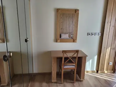 a room with a desk with a chair and a mirror at Pirin Golf Villa Sokol in Bansko