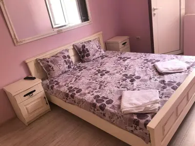 a bedroom with a bed with a purple comforter at Guest House Robin Hud in Cherni Osŭm