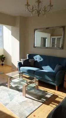 a blue couch in a living room with a mirror at Sunny and Charming Domain for Your Stay in Sofia in Sofia