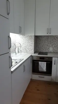 a kitchen with white cabinets and a stove and a sink at Sunny and Charming Domain for Your Stay in Sofia in Sofia