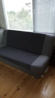 a couch sitting in front of a window at Sunny and Charming Domain for Your Stay in Sofia in Sofia