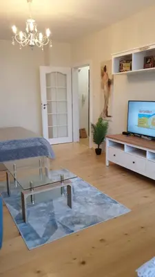 a living room with a glass table and a tv at Sunny and Charming Domain for Your Stay in Sofia in Sofia