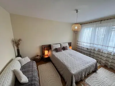 a bedroom with two beds and a couch at Lovely cozy vintage apartment in Kyustendil