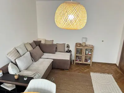 a living room with a couch and a chandelier at Lovely cozy vintage apartment in Kyustendil