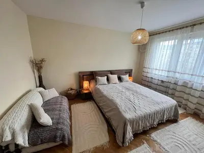 a bedroom with two beds and a large window at Lovely cozy vintage apartment in Kyustendil