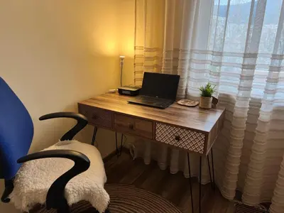 a desk with a laptop computer on it in front of a window at Lovely cozy vintage apartment in Kyustendil