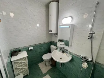 a bathroom with a sink and a toilet and a mirror at Lovely cozy vintage apartment in Kyustendil