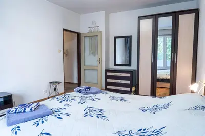 a bedroom with a large bed with blue and white sheets at The Lindens 1 Bedroom Cozy Apartment plus Free Parking!!! in Sofia