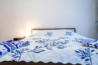 a bed with a blue and white blanket on it at The Lindens 1 Bedroom Cozy Apartment plus Free Parking!!! in Sofia