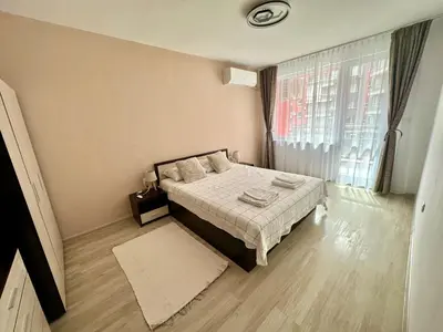 a bedroom with a bed and a large window at TVS Apartment-City centre in Plovdiv