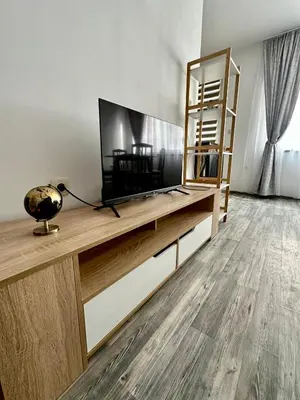 a living room with a flat screen tv on a entertainment center at TVS Apartment-City centre in Plovdiv