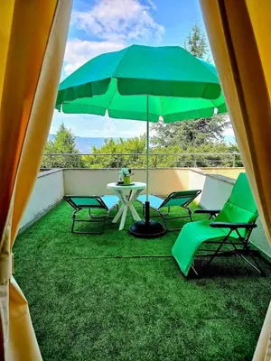 a patio with a table and chairs and an umbrella at Apartment - Studio Cucetno in Sandanski