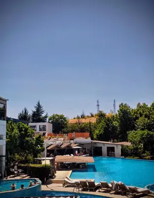 a large swimming pool with chairs and a resort at Apartment - Studio Cucetno in Sandanski