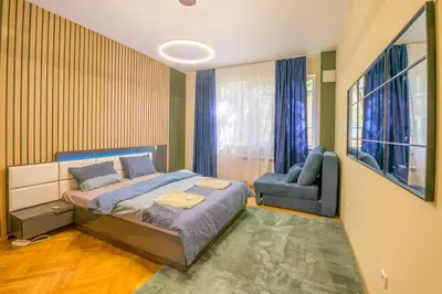 a bedroom with a bed and a couch and a chair at 1 Minute Walk to Main Street Vitoshka, NDK, Free Parking, 2 BDR in Sofia