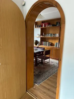 an archway leading into a dining room with a table at Spacious artsy apartment in Sofia