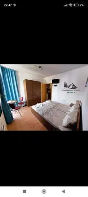 a large bedroom with a large bed and blue curtains at Comfy Studio in Bansko
