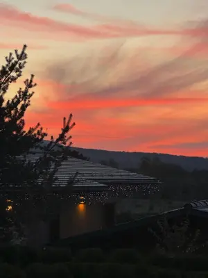a sunset view of a building with a sky at Pirin Golf Cozy Mountain Apartment with Views of Pirin & Rila in Bansko