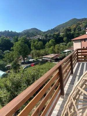 a wooden balcony with a view of a town at Mountain Whisper Guesthouse in Smolyan