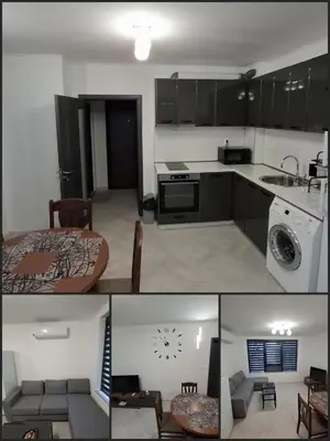 a kitchen with black cabinets and a room with a table at Апартамент Актив Спорт Гранд in Pazardzhik