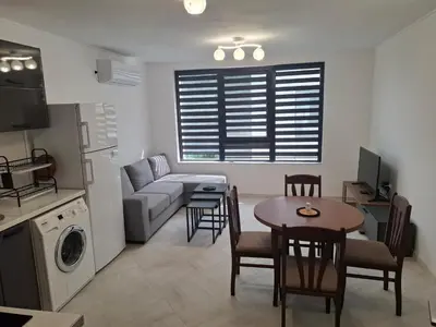 a living room with a couch and a table with chairs at Апартамент Актив Спорт Гранд in Pazardzhik