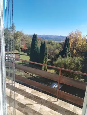 a view from a balcony with a fence and trees at Вила 