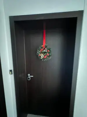 a black door with a wreath on it at Rose studio - Bulgaria mall, Brand New, Ground floor, Family-friendly, Baby cot&chair, Mountain view, Self check-in, Free Public parking and Paid underground in the mall in Sofia