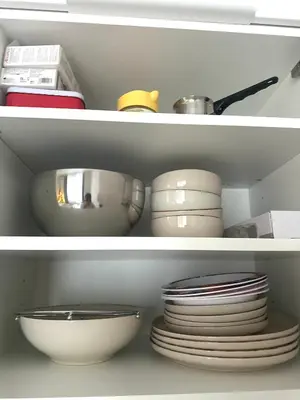 a white cabinet filled with dishes and bowls and plates at Rose studio - Bulgaria mall, Brand New, Ground floor, Family-friendly, Baby cot&chair, Mountain view, Self check-in, Free Public parking and Paid underground in the mall in Sofia