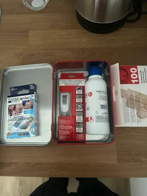 a suitcase on a table with medicines and a magazine at Rose studio - Bulgaria mall, Brand New, Ground floor, Family-friendly, Baby cot&chair, Mountain view, Self check-in, Free Public parking and Paid underground in the mall in Sofia