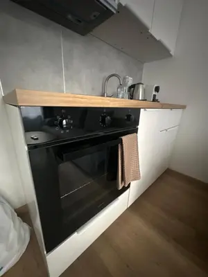 a kitchen with a black stove and a sink at Rose studio - Bulgaria mall, Brand New, Ground floor, Family-friendly, Baby cot&chair, Mountain view, Self check-in, Free Public parking and Paid underground in the mall in Sofia