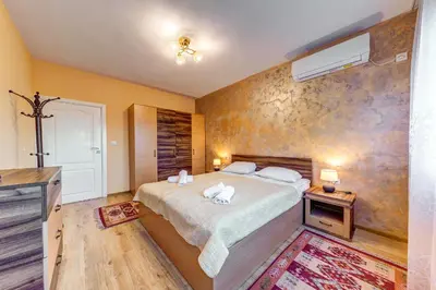 a bedroom with a bed and a wall at Bright retreat with Balcony & Mountain Views by Flat Manаger in Smolyan