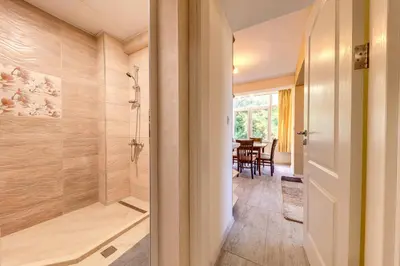 a bathroom with a shower and a dining room at Bright retreat with Balcony & Mountain Views by Flat Manаger in Smolyan