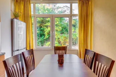 a dining room with a table and a large window at Bright retreat with Balcony & Mountain Views by Flat Manаger in Smolyan