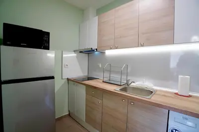 a kitchen with a sink and a refrigerator at Apartment near a Metro Station in Sofia