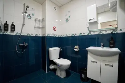 a blue and white bathroom with a toilet and a sink at Apartment near a Metro Station in Sofia