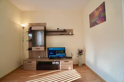 a living room with a television on a wooden cabinet at Apartment near a Metro Station in Sofia