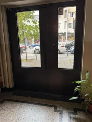 a black door with a window on a street at Happy Day in Sofia