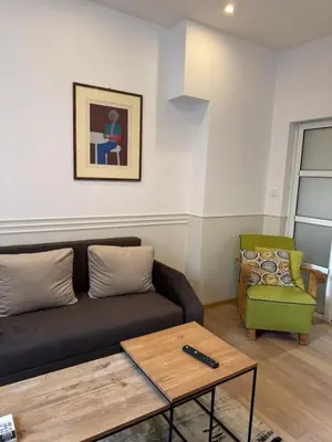 a living room with a black couch and a green chair at Happy Day in Sofia