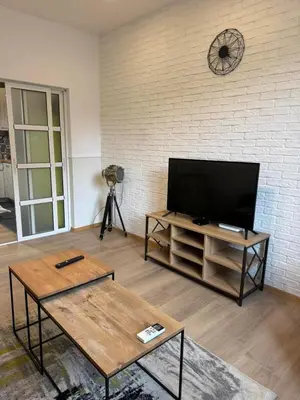 a living room with a flat screen tv on a brick wall at Happy Day in Sofia