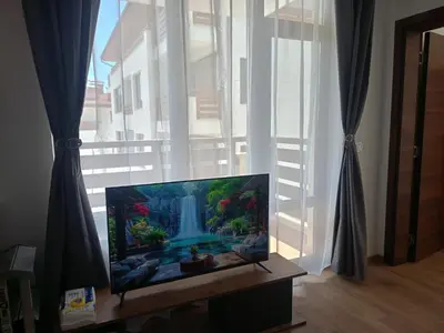 a flat screen tv sitting in front of a window at Apartment B35, complex Sokolitsite in Pamporovo