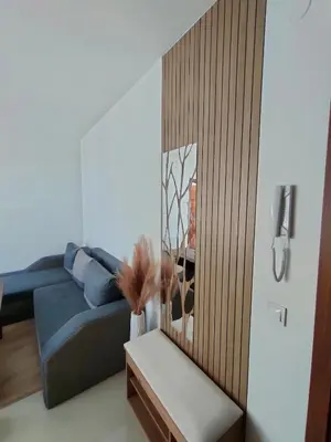 a living room with a blue couch and a mirror at Apartment B35, complex Sokolitsite in Pamporovo