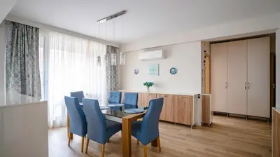 a dining room with a table and blue chairs at Modern & Spacious Stay by Flat Mаnager in Sofia