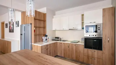 a kitchen with wooden cabinets and a stainless steel refrigerator at Modern & Spacious Stay by Flat Mаnager in Sofia