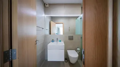 a bathroom with a toilet and a sink and a mirror at Modern & Spacious Stay by Flat Mаnager in Sofia
