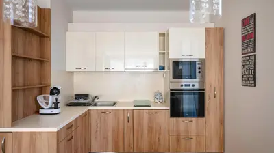 a kitchen with wooden cabinets and a stove top oven at Modern & Spacious Stay by Flat Mаnager in Sofia