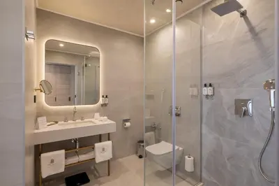 a bathroom with a shower and a toilet and a sink at East Plaza Hotel in Sofia