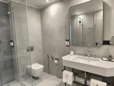 a bathroom with a toilet and a sink and a shower at East Plaza Hotel in Sofia